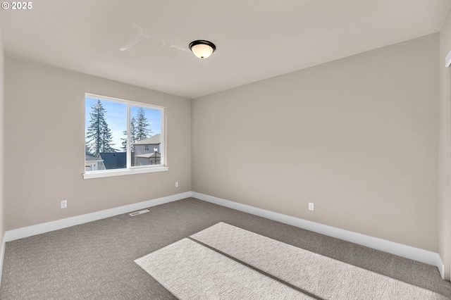empty room featuring baseboards, visible vents, and carpet flooring