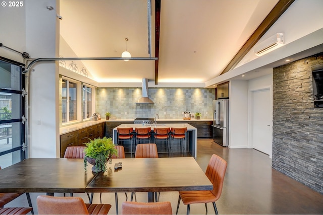 dining room featuring concrete flooring and high vaulted ceiling