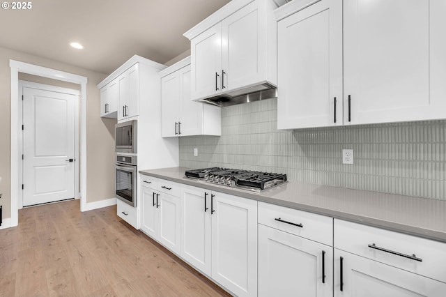 kitchen featuring white cabinets, baseboards, recessed lighting, and appliances with stainless steel finishes