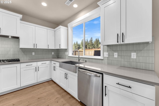 kitchen with a sink, appliances with stainless steel finishes, white cabinetry, visible vents, and recessed lighting