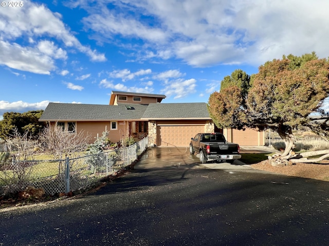 view of front facade featuring an attached garage, fence, and concrete driveway