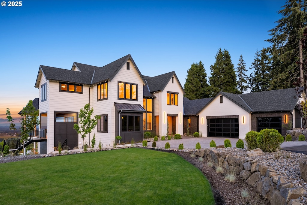 modern farmhouse style home featuring a garage and a lawn