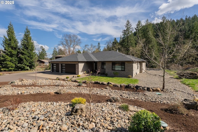 view of front of property featuring brick siding, driveway, and an attached garage