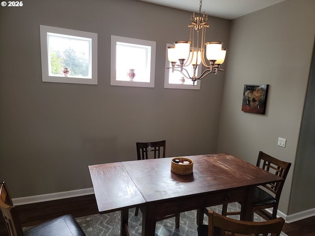 dining area featuring dark wood-type flooring and a chandelier