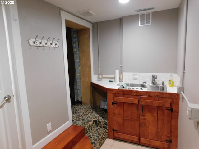 bathroom with tile patterned floors, sink, and backsplash