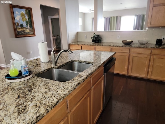 kitchen featuring dishwasher, light stone countertops, sink, and decorative backsplash