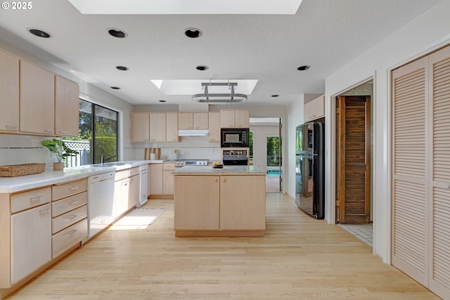 17141 Hofer Ct, Lake Oswego, OR 97034 - kitchen featuring a skylight, black appliances, light brown cabinetry, decorative backsplash, and recessed lighting
