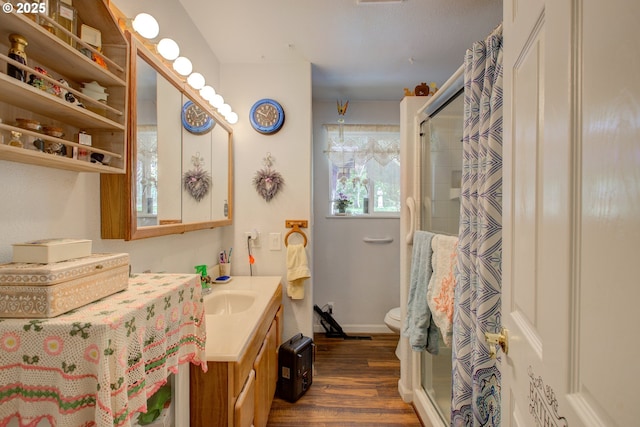 590 Fairchild St, Canyonville, OR 97417 - bathroom featuring wood finished floors, toilet, vanity, baseboards, and a stall shower