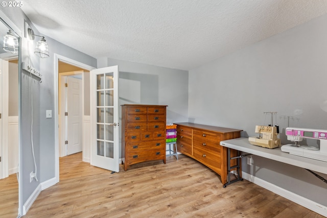 17948 SW Robert Ln, Beaverton, OR 97078 - bedroom with light wood-style floors, a textured ceiling, french doors, and baseboards