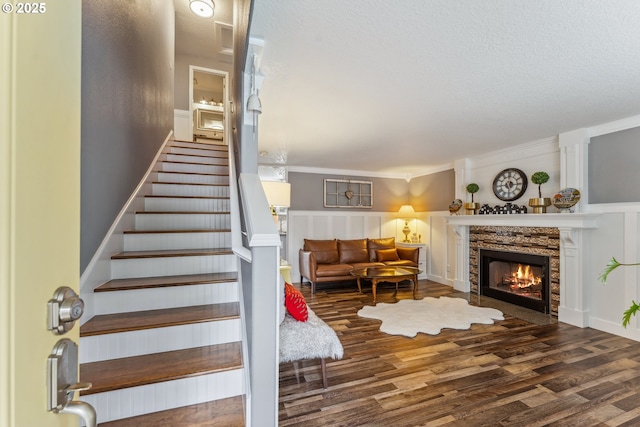 17948 SW Robert Ln, Beaverton, OR 97078 - stairs featuring a warm lit fireplace, wood finished floors, ornamental molding, and a textured ceiling
