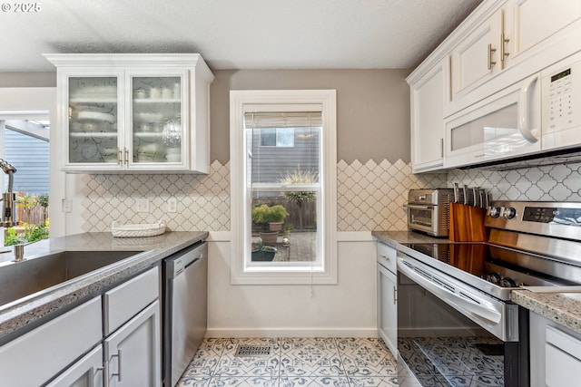 17948 SW Robert Ln, Beaverton, OR 97078 - kitchen with stainless steel appliances, a sink, healthy amount of natural light, and white cabinets