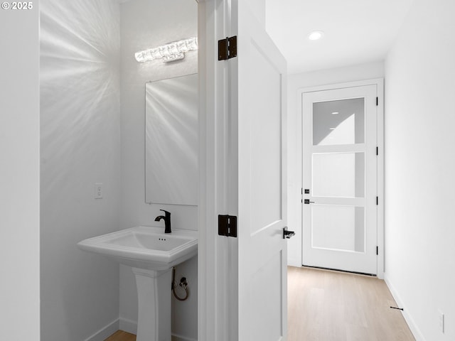 bathroom with baseboards and wood finished floors