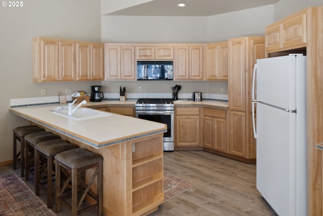 18144 Maury Mountain Ln, Sunriver, OR 97707 - kitchen with freestanding refrigerator, light brown cabinetry, and black microwave