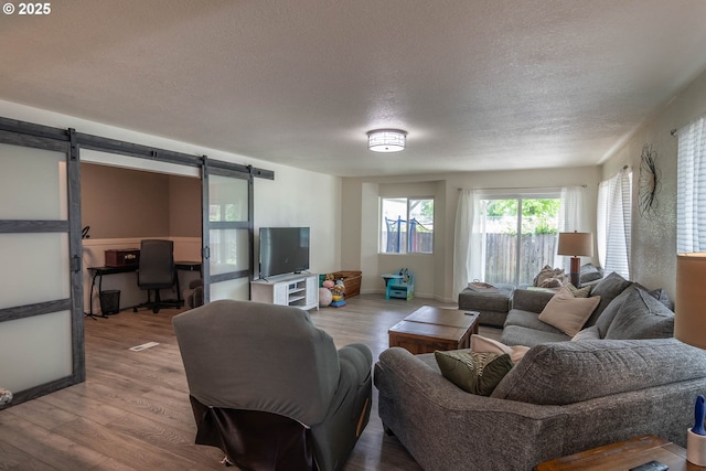 4033 Hanna St, Roseburg, OR 97471 - living room with a barn door, a textured ceiling, wood finished floors, and a desk