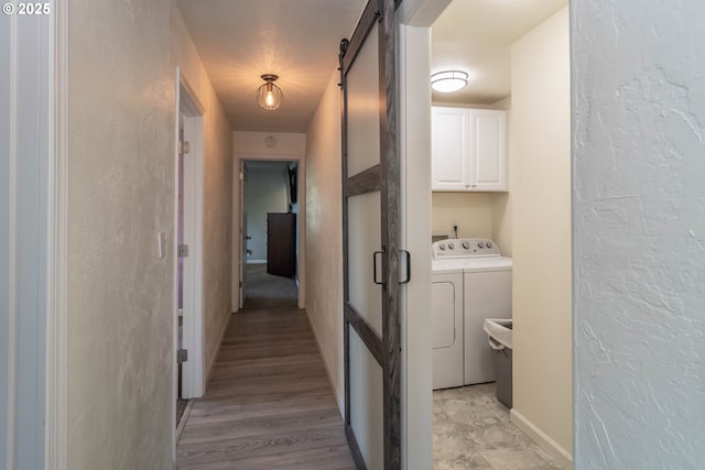 4033 Hanna St, Roseburg, OR 97471 - clothes washing area with washer and dryer, a barn door, cabinet space, a textured wall, and baseboards