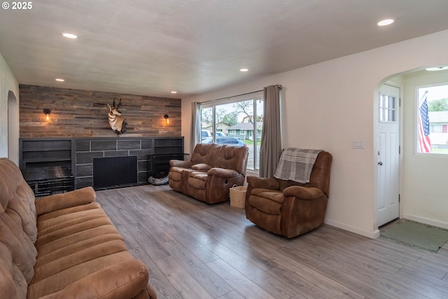 4033 Hanna St, Roseburg, OR 97471 - living room with arched walkways, a tiled fireplace, wood finished floors, recessed lighting, and wood walls