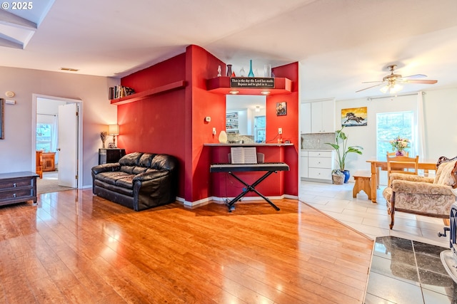 living area featuring visible vents, light wood-style flooring, and a ceiling fan