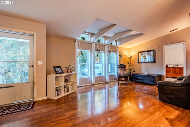 living area with a healthy amount of sunlight, visible vents, and vaulted ceiling