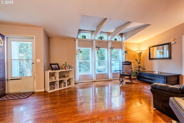 living room with lofted ceiling, hardwood / wood-style floors, and baseboards