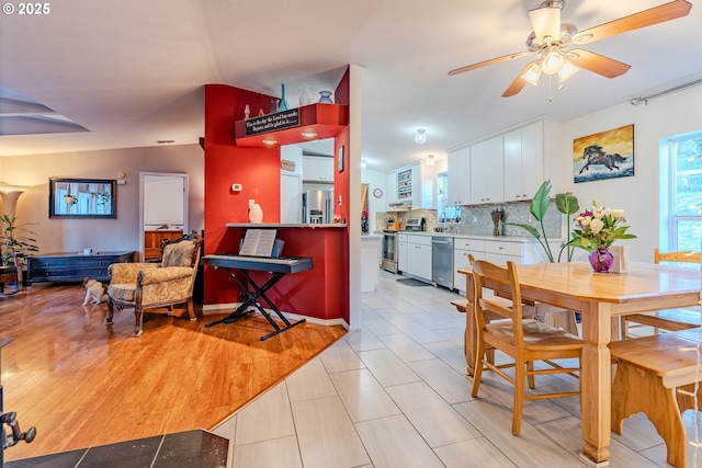 dining area featuring light wood-style floors, lofted ceiling, and a ceiling fan