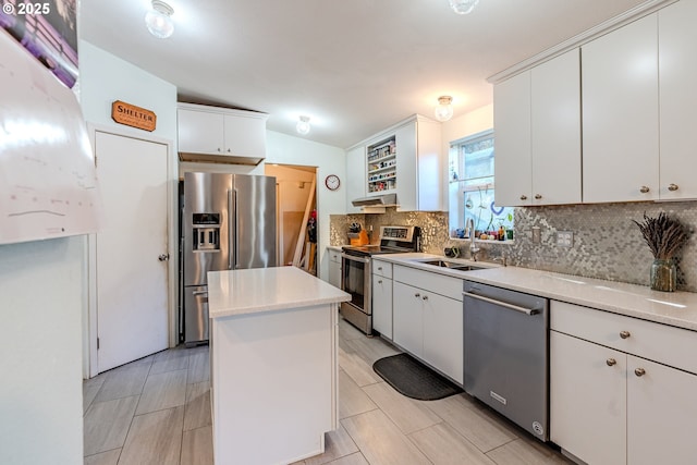 kitchen with decorative backsplash, appliances with stainless steel finishes, light countertops, under cabinet range hood, and a sink