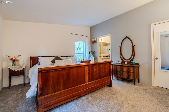 bedroom with carpet floors, vaulted ceiling, and ensuite bathroom