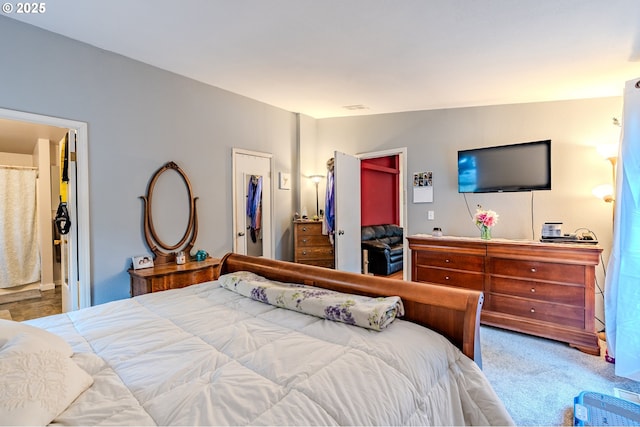 bedroom with carpet floors, visible vents, a spacious closet, a closet, and ensuite bath