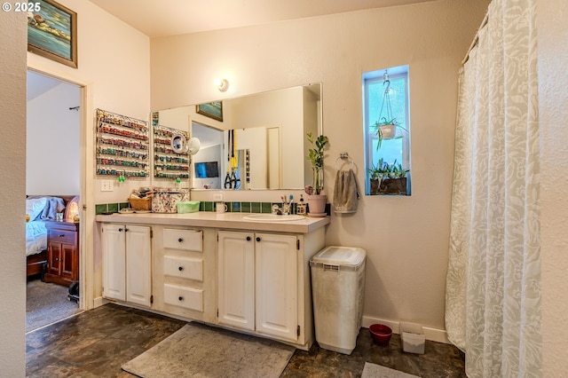 bathroom featuring stone finish floor, connected bathroom, vanity, and baseboards