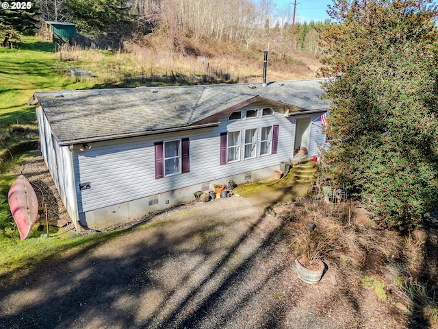 view of front of home with crawl space and a shingled roof