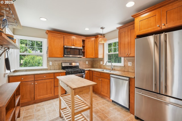 6134 NE 25th Ave, Portland, OR 97211 - kitchen with stainless steel appliances, a sink, brown cabinetry, backsplash, and recessed lighting