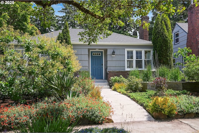 6134 NE 25th Ave, Portland, OR 97211 - bungalow-style house with roof with shingles, brick siding, and a chimney