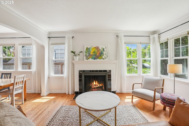 6134 NE 25th Ave, Portland, OR 97211 - living area with a tile fireplace, light wood-style floors, healthy amount of natural light, and crown molding