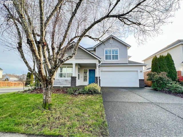 view of front of home featuring a garage, a front yard, and covered porch