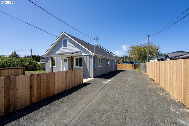bungalow-style home with driveway and board and batten siding