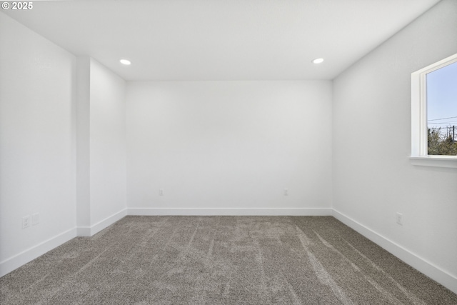 carpeted spare room featuring baseboards and recessed lighting