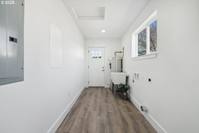 doorway featuring electric panel, wood finished floors, baseboards, water heater, and recessed lighting