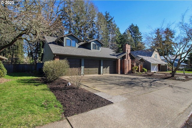 view of front of house featuring a garage, concrete driveway, a front yard, and fence