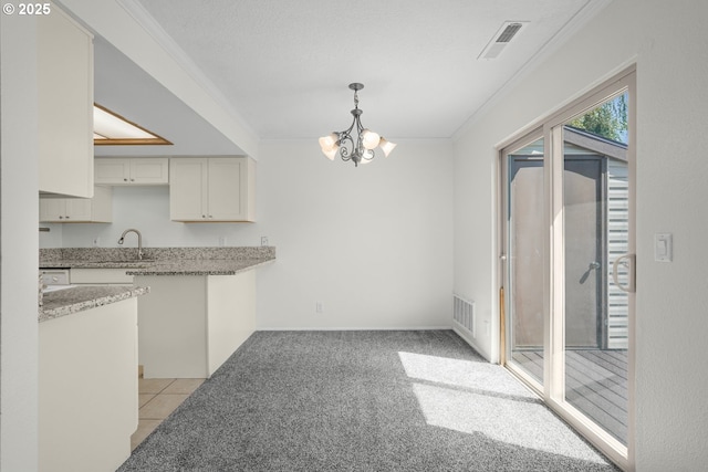 12510 SE Stark St Unit H, Portland, OR 97233 - kitchen featuring a chandelier, light colored carpet, crown molding, light stone countertops, and hanging light fixtures