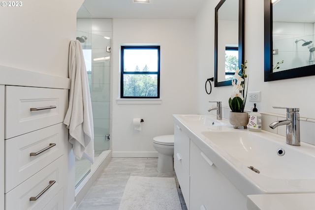 bathroom featuring a shower stall, toilet, baseboards, and a sink