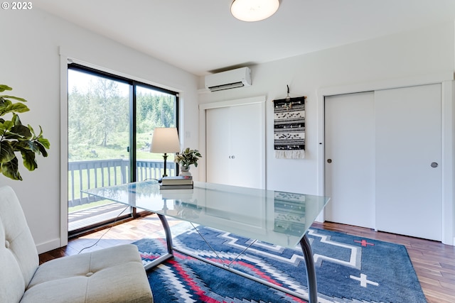 home office featuring wood finished floors and a wall mounted AC