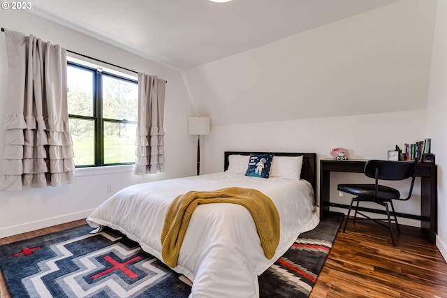 bedroom with baseboards, wood finished floors, and vaulted ceiling