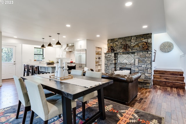 dining area with dark wood finished floors, recessed lighting, and a fireplace