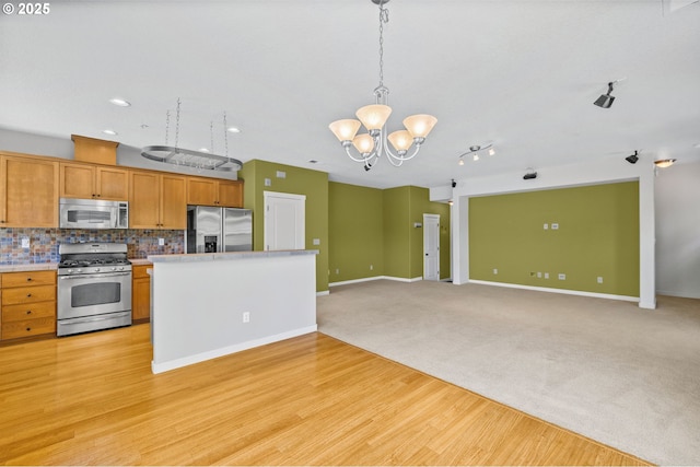 8844 NE Brentford Way, Hillsboro, OR 97006 - kitchen featuring stainless steel appliances, a chandelier, decorative backsplash, light countertops, and decorative light fixtures