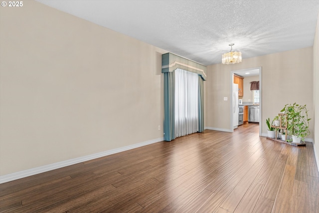 2462 NE 11th Ave, Hillsboro, OR 97124 - spare room featuring a chandelier, wood finished floors, baseboards, and a textured ceiling