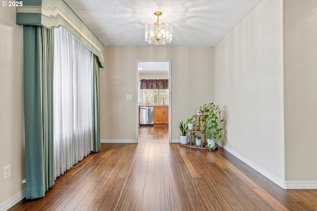 2462 NE 11th Ave, Hillsboro, OR 97124 - hall featuring a chandelier, hardwood / wood-style floors, and baseboards