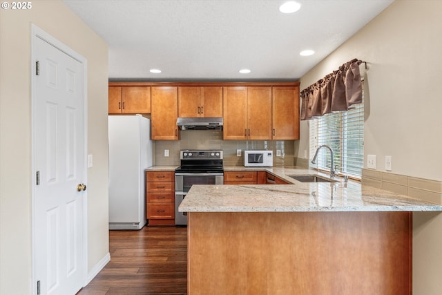 2462 NE 11th Ave, Hillsboro, OR 97124 - kitchen with a sink, white appliances, under cabinet range hood, a peninsula, and brown cabinetry