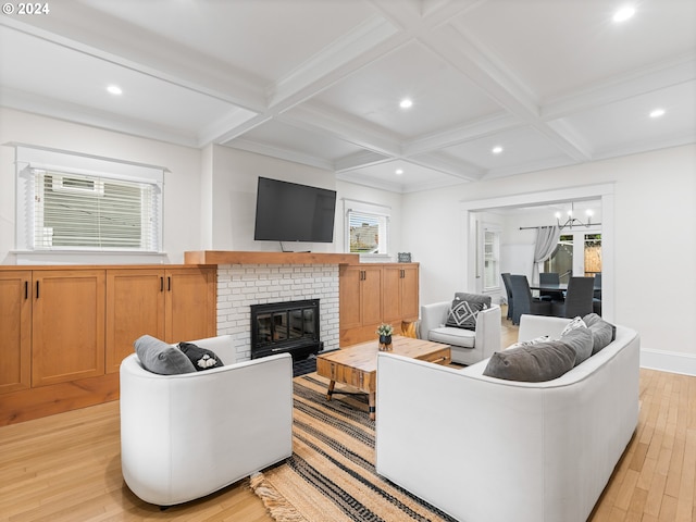 living room with a brick fireplace, plenty of natural light, beamed ceiling, and light wood-type flooring