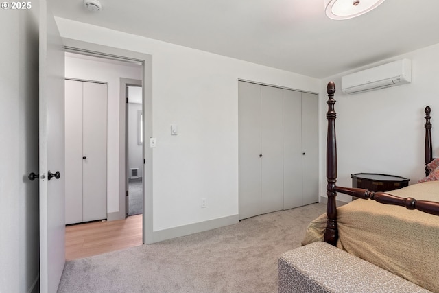 carpeted bedroom with baseboards, a wall mounted AC, a closet, and visible vents