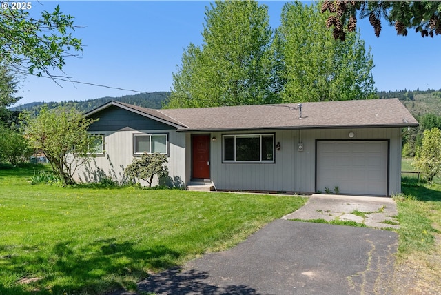 ranch-style house with an attached garage, a front lawn, aphalt driveway, and roof with shingles