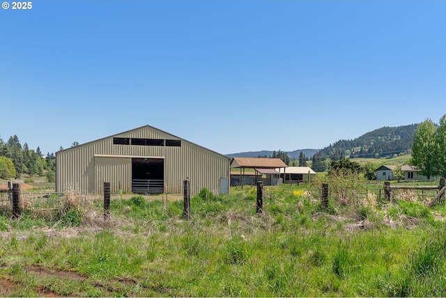 view of pole building with fence and a mountain view